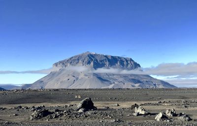 Scenic view of snowcapped mountains against blue sky