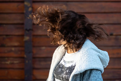 Rear view of woman standing against wall
