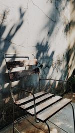 Abandoned chair against wall