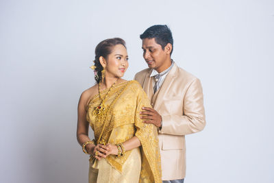 Young couple standing against white background