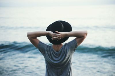 Man standing at beach against sky