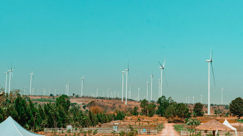 Panoramic view of wind turbines against sky