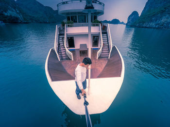 Rear view of man on boat against sea