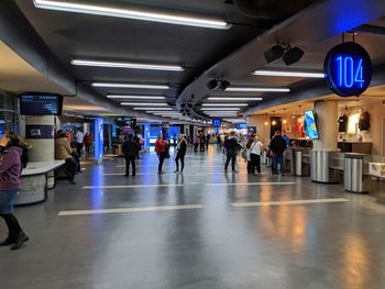 Group of people walking in illuminated subway station