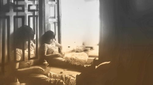 Children sitting in window at home