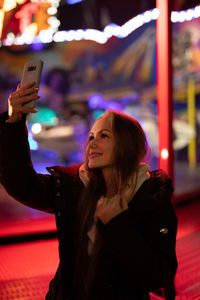 Young woman using mobile phone at night