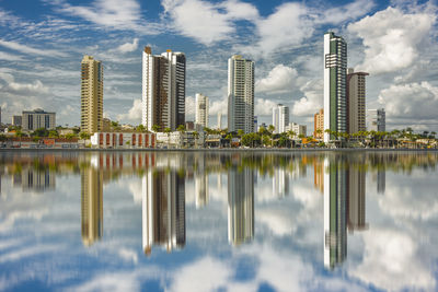 Reflection of buildings in lake against sky