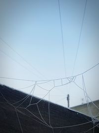 Low angle view of electricity pylon against clear sky