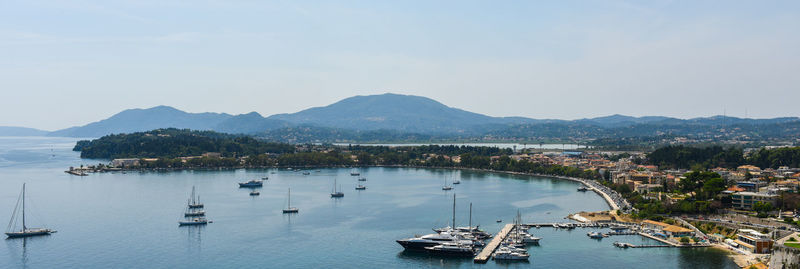 Boats moored at harbor against clear sky