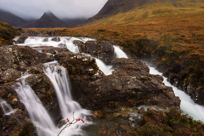 Scenic view of waterfall against sky