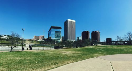 View of skyscrapers in park against blue sky