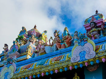 Low angle view of statues on building against sky