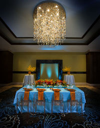 Illuminated chandelier on table at home