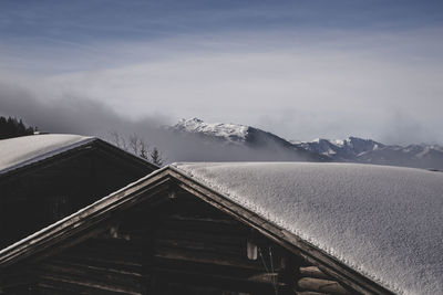 Scenic view of snowcapped mountains against sky and hut