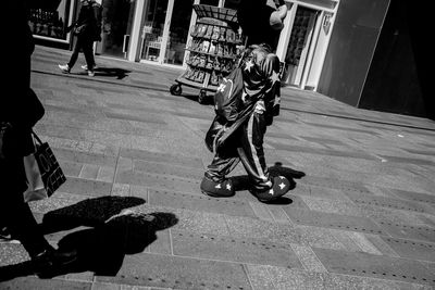 Performer wearing costume on footpath in city