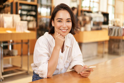 Portrait of businesswoman working at table in cafe