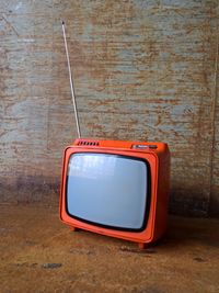Close-up view of old-fashioned tv against wall
