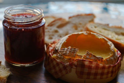 Close-up of camembert with jam bottle