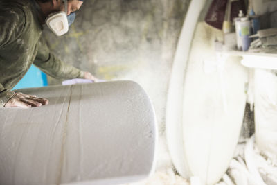 Surfboard shaper sanding a new design