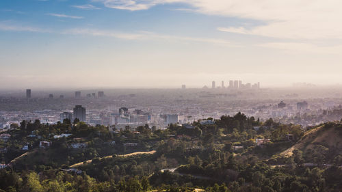 View of cityscape against cloudy sky