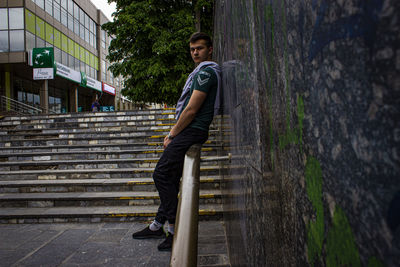 Portrait of young man standing on staircase