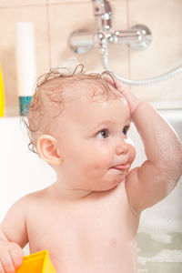 Girl playing with toys in bathtub