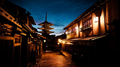 Street amidst buildings against sky at night