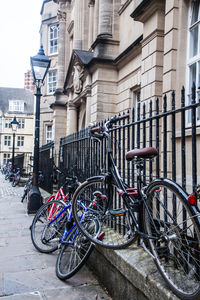 Bicycles on street in city against sky