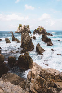 Rocks on sea shore against sky