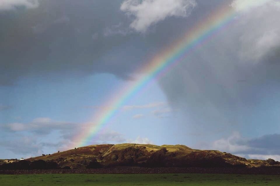 sky, rainbow, cloud - sky, scenics, cloudy, multi colored, beauty in nature, tranquility, tranquil scene, nature, landscape, cloud, idyllic, weather, outdoors, overcast, grass, no people, tree, day