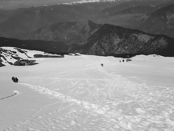 View of people skiing on snowcapped mountain