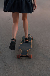 Low section of woman skateboarding in city
