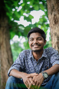 Portrait of smiling young man sitting outdoors