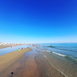 Scenic view of beach against clear blue sky