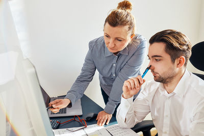 Two business people discussing financial data looking at computer screen. coworking people in office