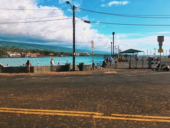 People on beach in city against sky