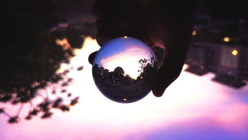 Digital composite image of hand holding crystal ball