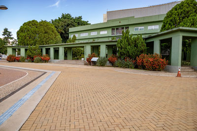 Footpath by building in city against sky