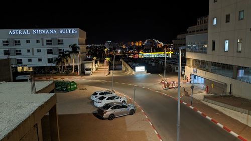 High angle view of illuminated street amidst buildings in city at night