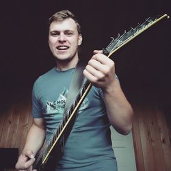 Portrait of smiling young man playing guitar