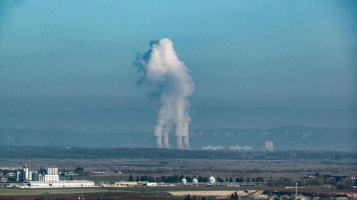 Smoke emitting from chimney against sky