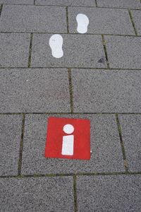 High angle view of arrow sign on sidewalk