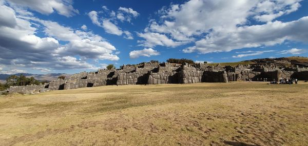 Panoramic view of castle on field against cloudy sky