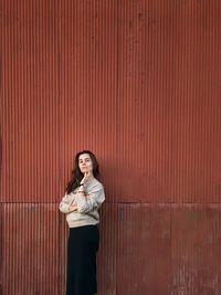 Portrait of woman standing against wall