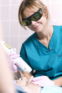 Close-up of woman getting beauty treatment from doctor