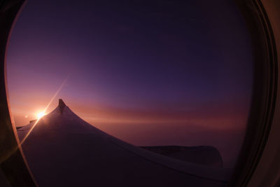 Scenic view of sky seen through airplane window during sunset