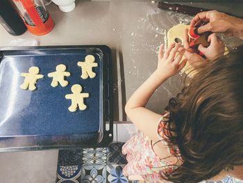 High angle view of little girl baking cookies 