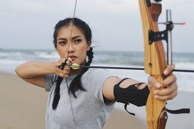 Sport girl.asian woman in black under shirt holding archery in hands.
