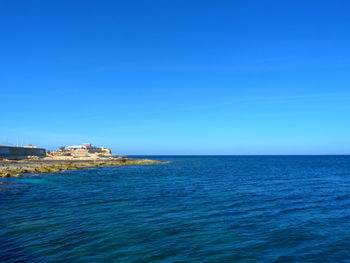 Scenic view of sea against clear blue sky