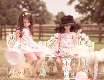 Girls sitting on chairs at table on field